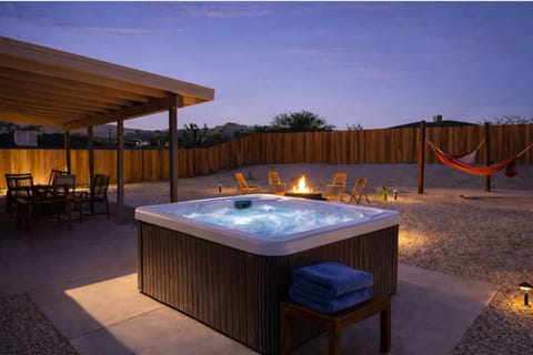 Private hot tub at dusk with fire pit and desert ambiance—perfect for relaxing under the stars