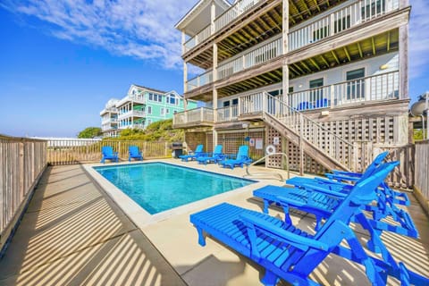 Dive into your private pool paradise, surrounded by bright blue lounge chairs perfect for soaking up the sun on your oceanside getaway.