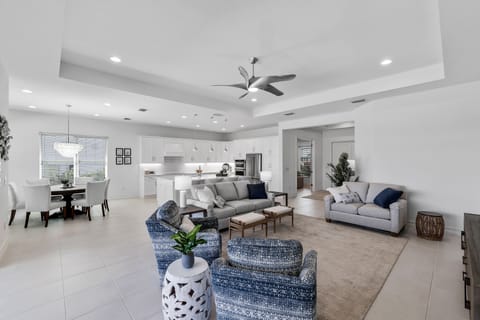 Open, airy, bright living area:  great room, dining room, kitchen with island.