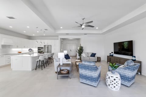 Great room with 2 sofas & 2 swivel chairs.  Kitchen island with 4 swivel chairs.