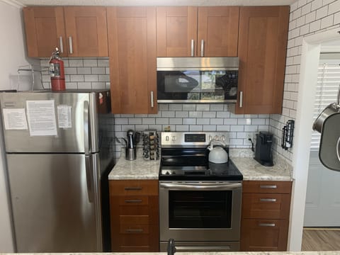 Newly remodeled kitchen- new countertops, microwave, stove, backsplash