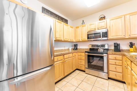 Full sized kitchen with granite countertops and stainless steel appliances.