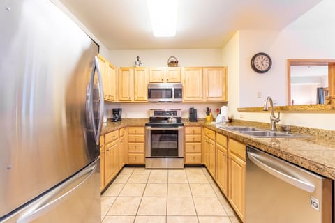 Full sized kitchen with granite countertops and stainless steel appliances.