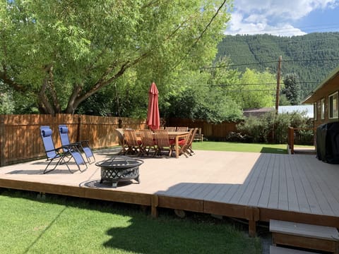 Back Deck with BBQ, outdoor chair, umbrella and sun chairs. Snow King Man behind