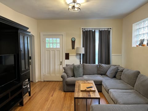 Living room w/ sectional sofa and 50" Vizio smart TV w/ streaming apps.
