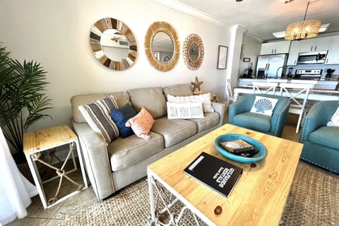 The living room includes a sleeper sofa and two chairs.