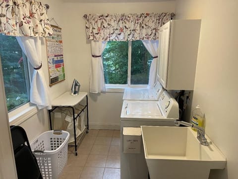 Full laundry with new washer and dryer, iron and ironing board and soap included
