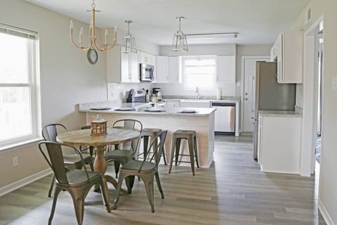 Ample seating for up to 8 guests, including a dining table for four and four bar stools at the counter.