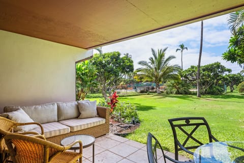 Relax on the covered lanai sweeping views of colorful tropical plants and flowers with direct access to the lawn and nearby pool