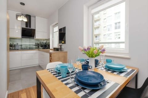 A sleek kitchen with white cabinets, black countertops, and a large window offering plenty of light.