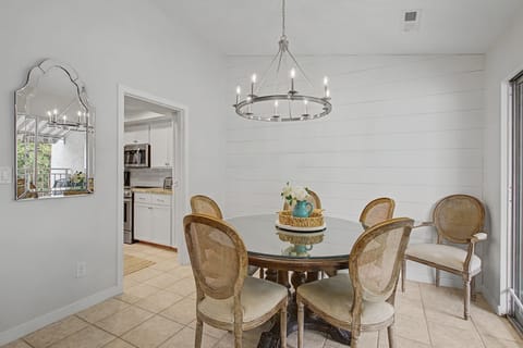 Gather around your elegant glass dining table for memorable meals under the warm glow of a stunning chandelier.