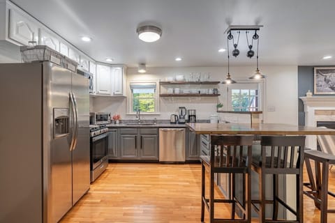 Fully equipped chef kitchen eat in bar counter, over looking fire place sitting.