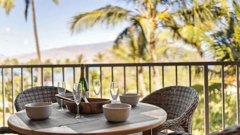 A cozy lanai dining setup overlooks swaying palms, creating a peaceful spot for morning coffee or evening wine.