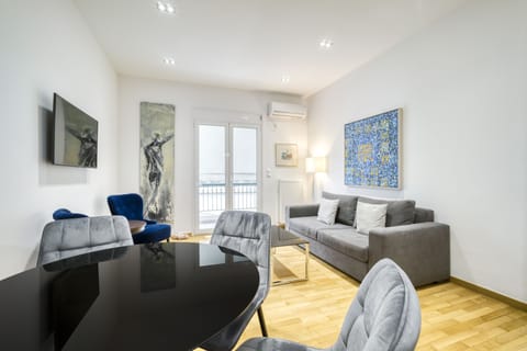 Main living area including dining area with table that doubles as work desk.