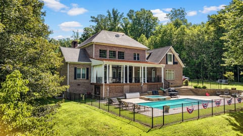 Pool and hot tub with slight slopes hill down to dock.