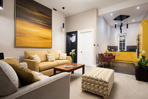 The Scott Apartment - open-plan living space has a spacious seating area and sleek yellow kitchen