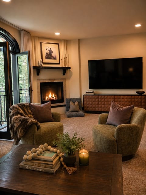 Curl up in plush seating by a crackling fireplace—your cozy retreat after a day of exploring. Soft textures and warm lighting create the perfect spot to unwind.