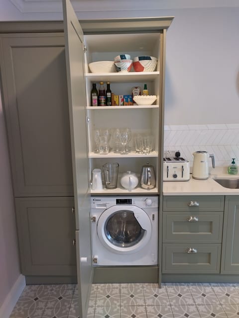 The kitchen has a washer dryer, dish washer, oven, microwave and hob.