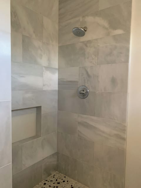 marble walk in shower , glass doors