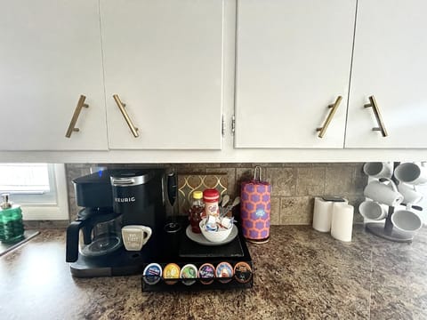 Coffee bar with Keurig and full pot. There’s a coffee bean grinder and K-cups.