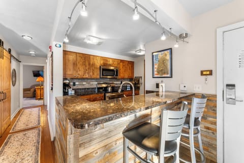 Updated full size kitchen with granite countertops, stainless steel appliances, and breakfast bar for additional seating