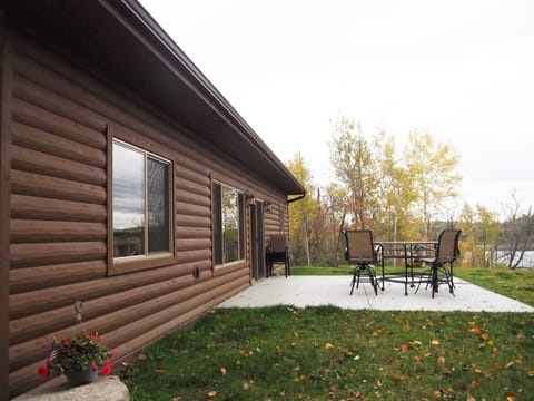 Patio with high top table, chair and gas grill.