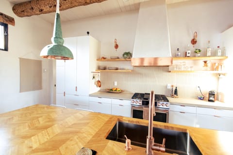 Six burner GE Cafe range with oven and spacious single basin sink.