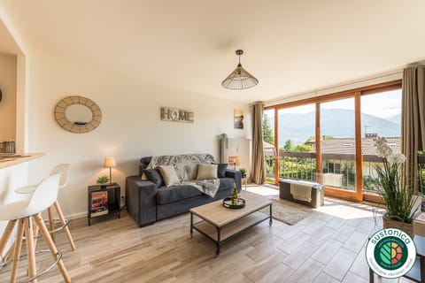 Living room with sofa bed, bay window with lake and mountain views