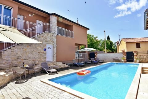 The exterior of the apartment with balcony, swimming pool in the garden.