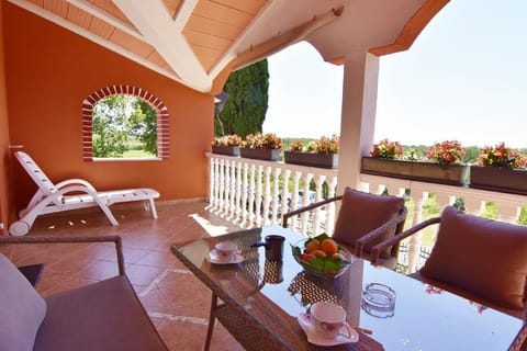 The large terrace with garden furniture and deck chairs offers a view of the countryside.