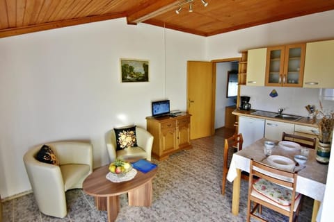 The living area with a kitchen and dining table with three chairs.