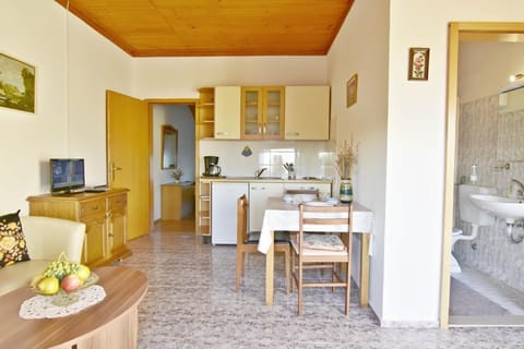 The kitchen equipped with a stove, refrigerator, coffee maker, dining table and chairs