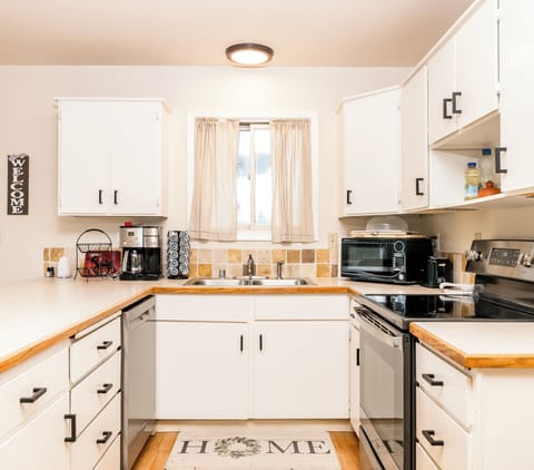 Kitchen with a combo k-cup and pot coffee maker, toaster, microwave, and oven.
