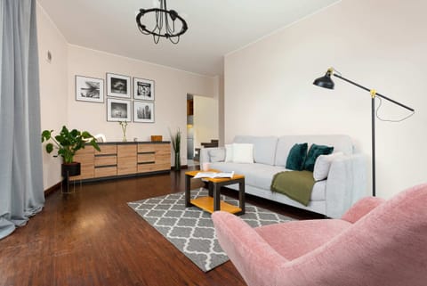 A cozy living room with wooden furniture, a light-colored sofa, and decorative plants, creating a homey ambiance.