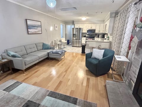 Larger couch and ottoman, open to kitchen