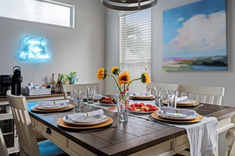 Gather around the cozy dining table, set for six with a touch of beach charm.