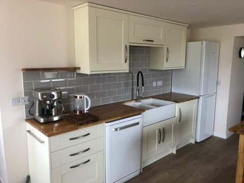 Kitchen with under cabinet lighting . Fridge freezer.