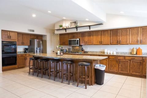 Large open fully stocked kitchen w/ stainless steel appliances and granite countertops w/ seating