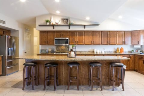 Large open fully stocked kitchen w/ stainless steel appliances and granite countertops w/ seating