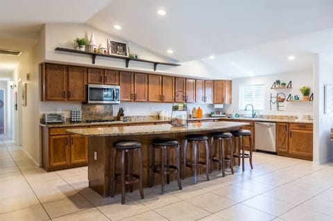 Large open fully stocked kitchen w/ stainless steel appliances and granite countertops w/ seating