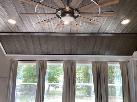 Wood stained ceiling with big ceiling fan.