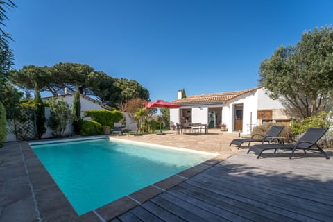 Large exterior with swimming pool, sunbathing terrace and outdoor dining table