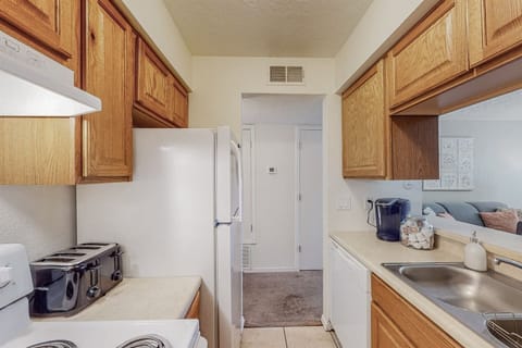 Kitchen includes coffee maker, refrigerator, electric stove, and dishwasher