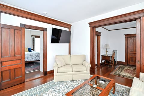 Living room with sofa, love seat, pocket door into dining room