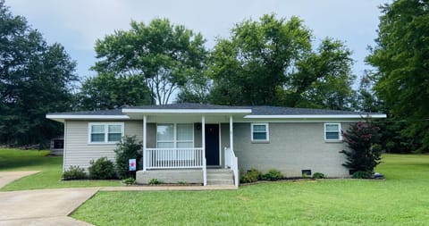 Front of the house with porch and concrete driveway. 