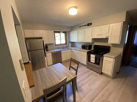 Kitchen fully set up with stainless steel appliances, dishes and cookware