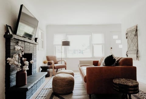 Living room with smart tv and leather couch, reading chair