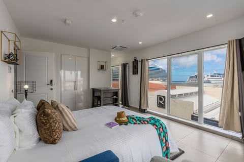 Drift off in your bright, modern bedroom as you watch cruise ships glide by through floor-to-ceiling windows. Fresh, breezy décor and waterfront views make this your perfect coastal retreat.