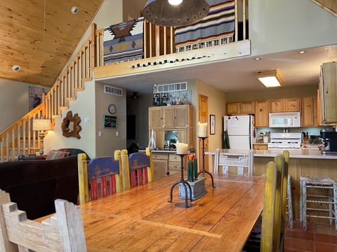 Open concept dining room and kitchen showing stairs to loft area. 