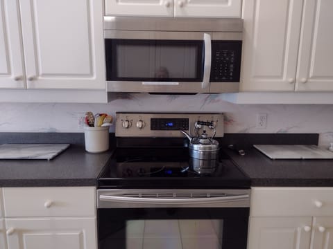 A clean kitchen complete with a tea kettle!